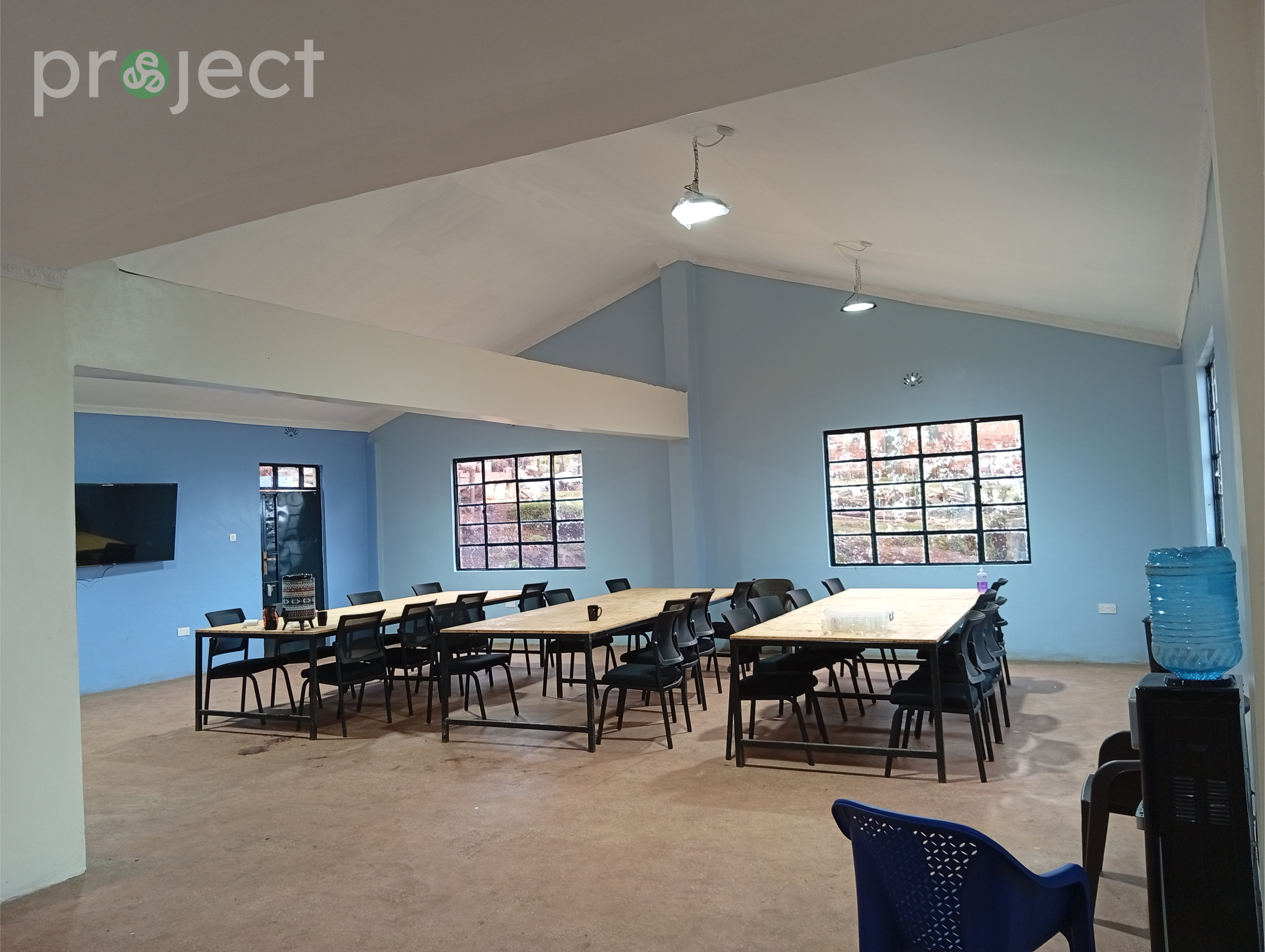 Spacious digital training room at the David Connor Trinitech Center with long tables, chairs, and screens ready for technology and workforce development courses.